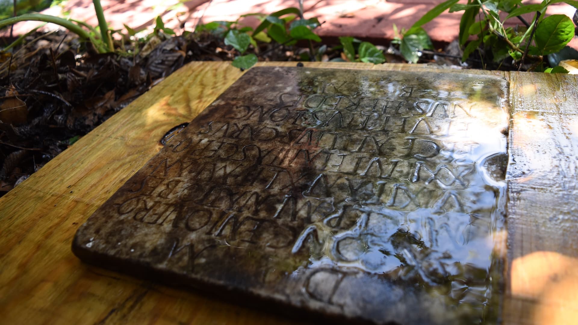 a close-up of a square tombstone with Latin inscriptions