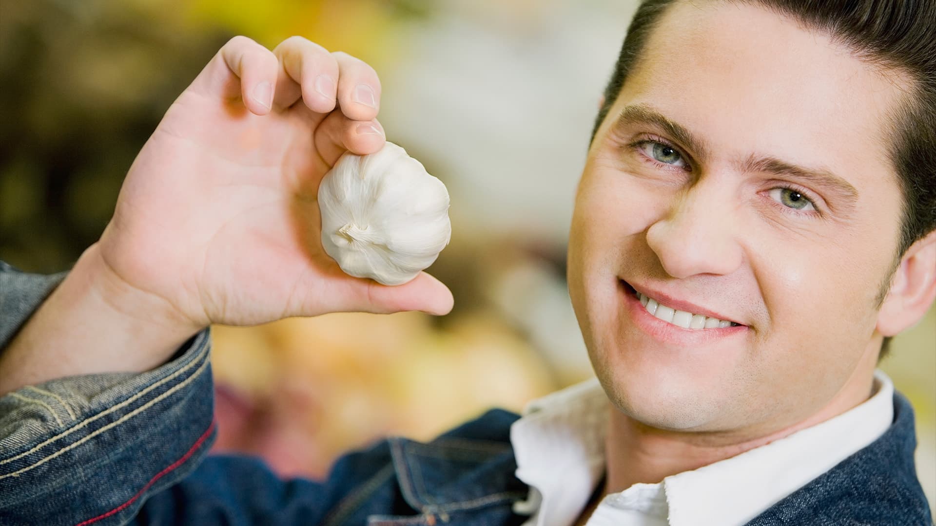 Người đàn ông nhăn mặt cầm củ tỏi