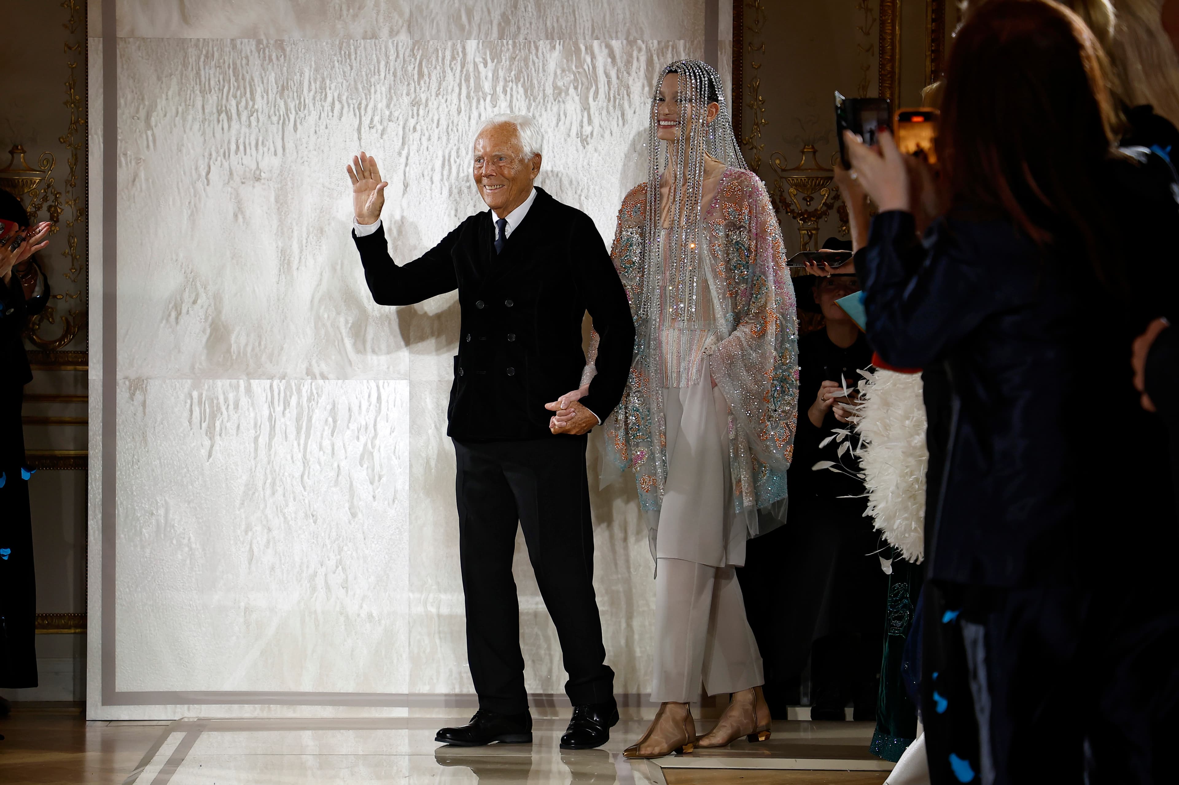 Giorgio Armani takes a bow with a model at the Armani Privé show in January 2025