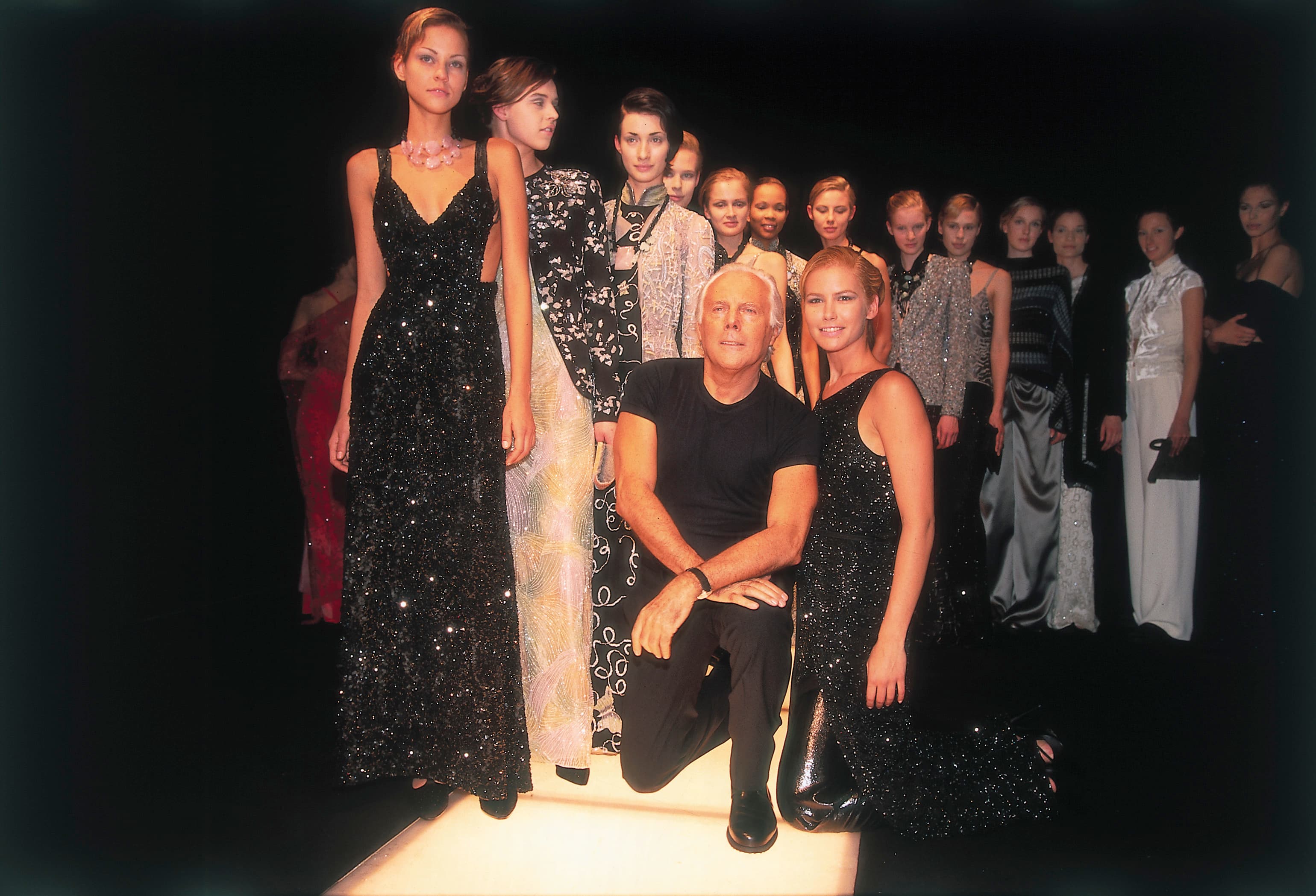 Giorgio Armani poses with models at one of his fashion shows in the 1990s