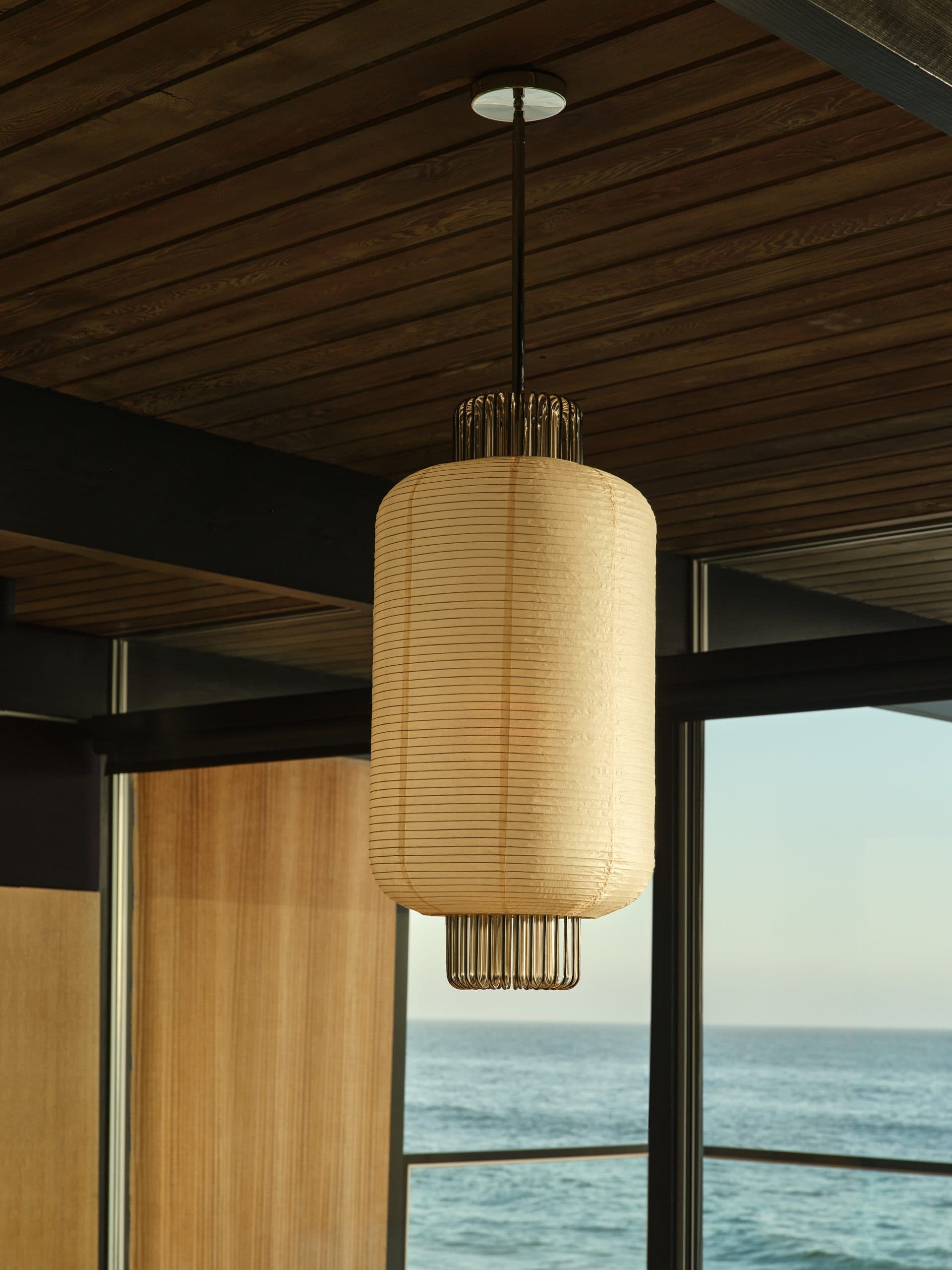 Một Nagaro pendant light treo trên trần gỗ.