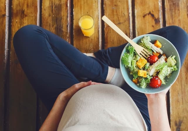 phụ nữ mang thai cầm bát salad